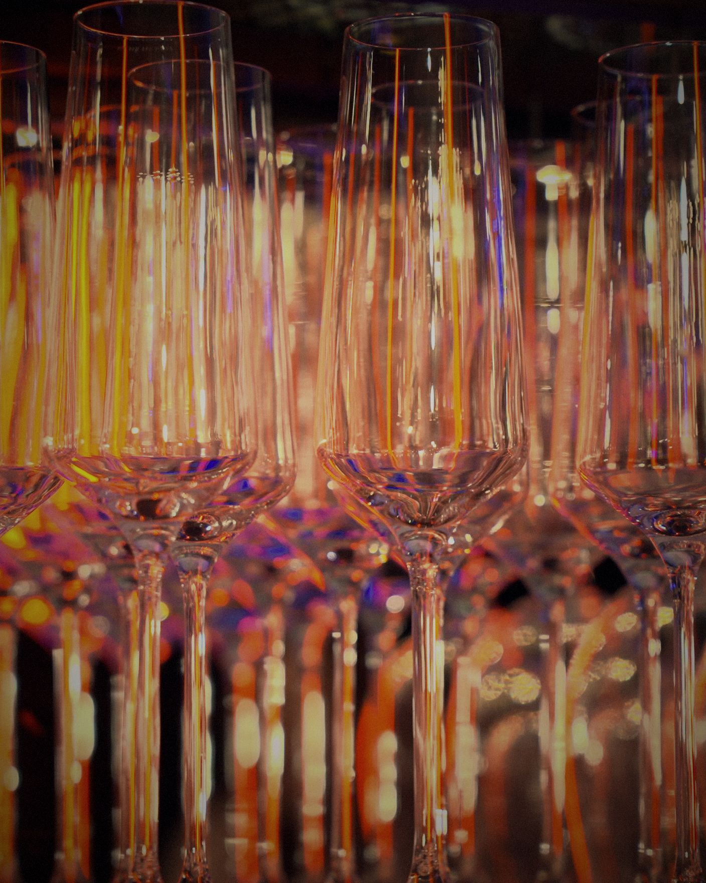 Rows of crystal champagne flutes glowing behind the bar